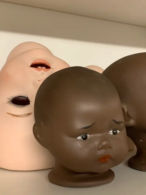 Painted bisque porcelain doll heads arranged in a row